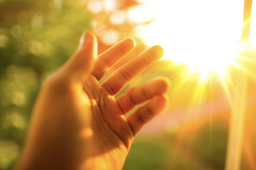 手を太陽にかざしてる