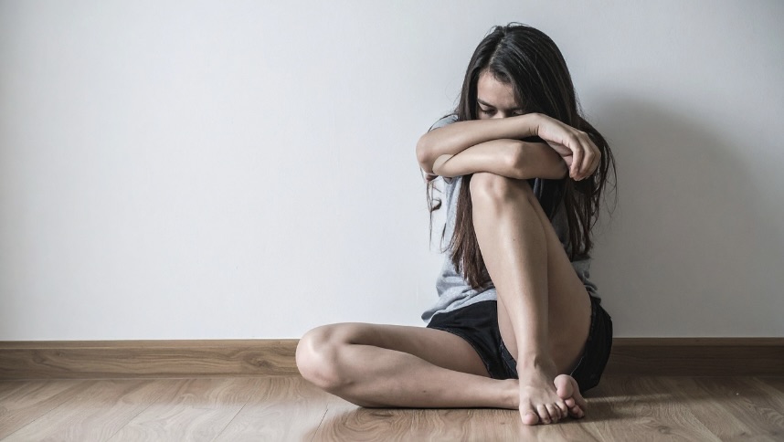 膝を抱える女性